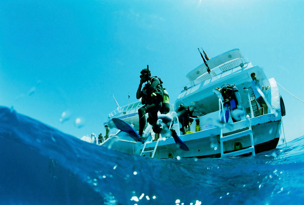 People jumping off boat to scuba dive