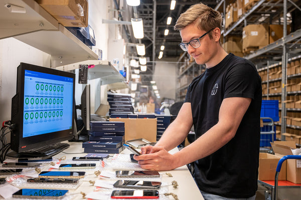 Mathias sjekker kvaliteten på telefonene