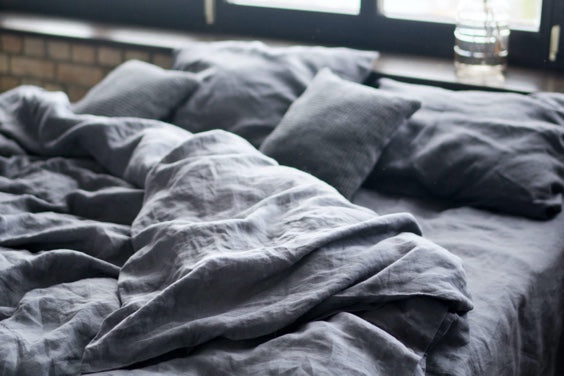 organic linen bedding in dark gray color on a bed