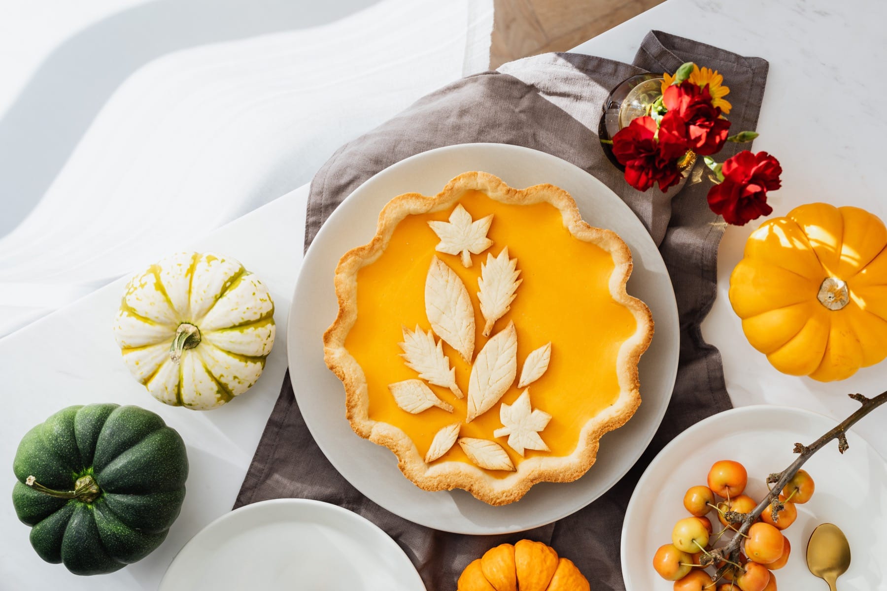 Pumpkin pie on Thanksgiving table with pumpkins
