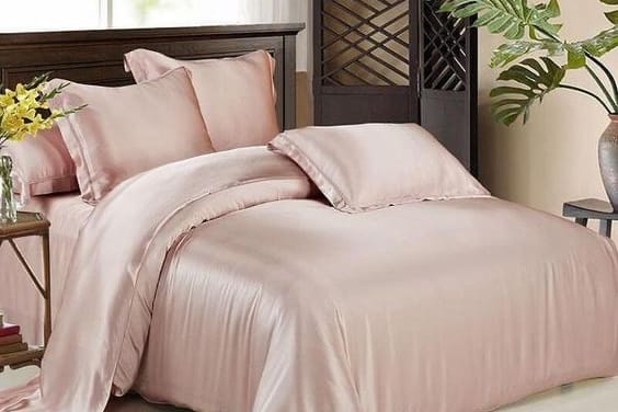 pink silk bedding on a bed