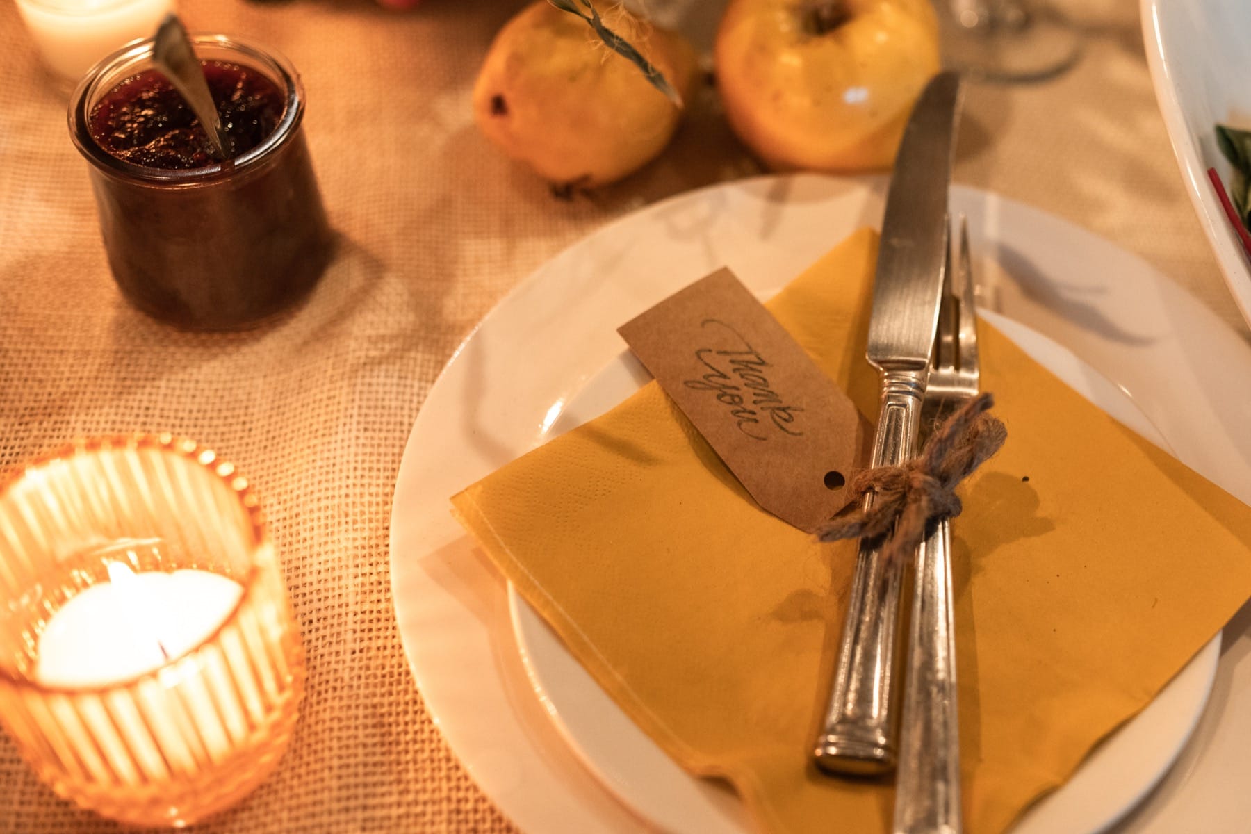 Thanksgiving table with silverware and orange napkin on a plate