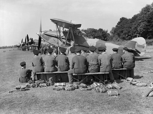 Aircraft apprentices of No. 1 School of Technical Training listen to a lecture on servicing aircraft in the field, in front of a line of instructional airframes on the airfield at Halton, Buckinghamshire. 989M is a Hawker Audax Mark I, formerly K3057 of No. 2 Squadron RAF, reduced to airframe status in 1937.