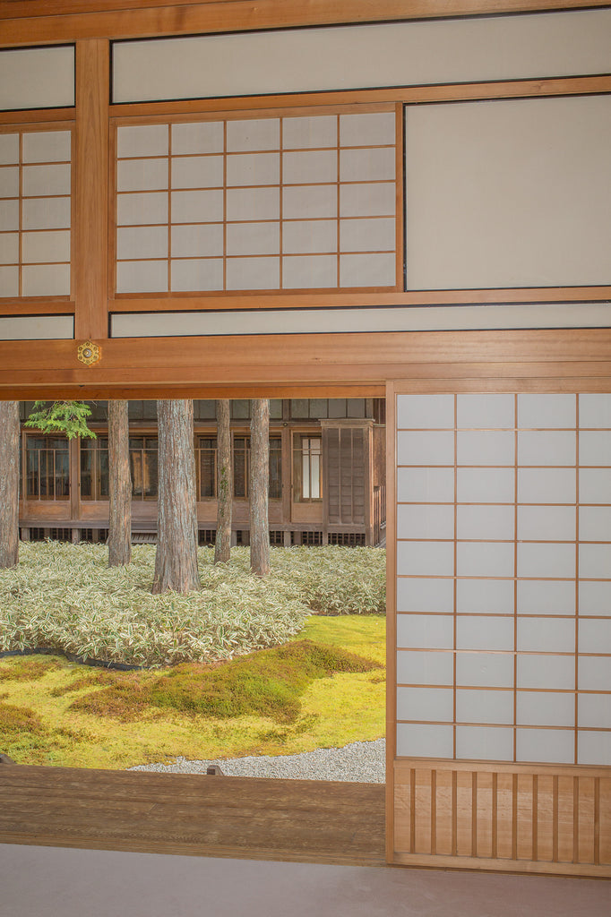 Inside a building with traditional Japanese architecture and a view to the outdoor garden