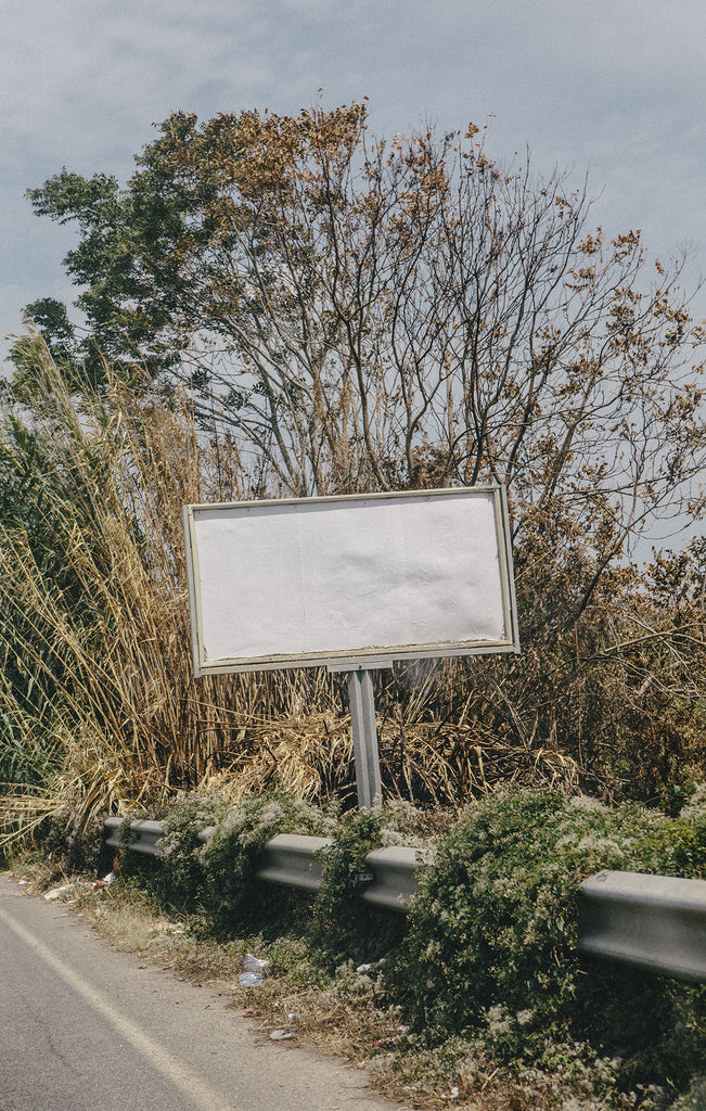 Blank white sign on the side of a road 