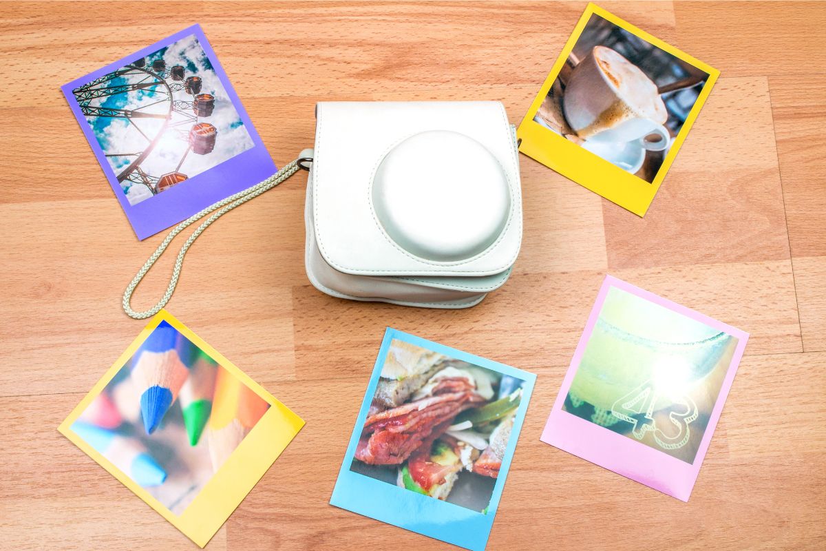 Instant camera with photos scattered around it