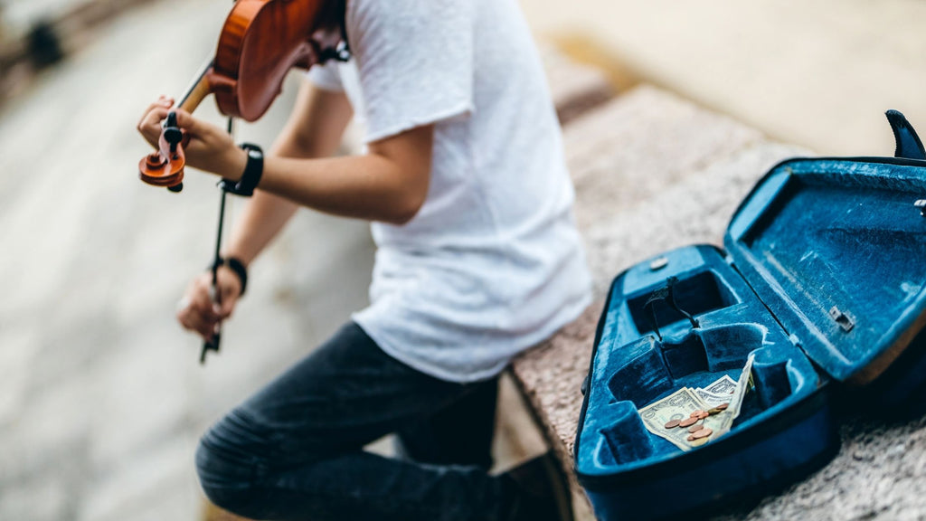 A photo of a busker playing the violin. 