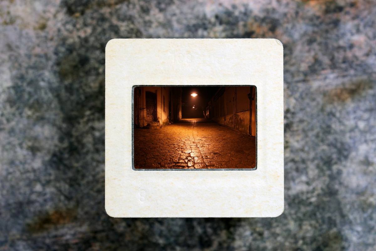 Slide film in frame with a photo of dimly lit alley.