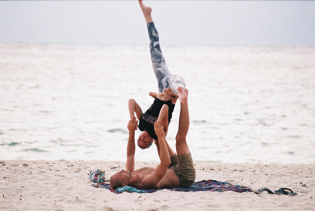 practicing acro yoga on the beach