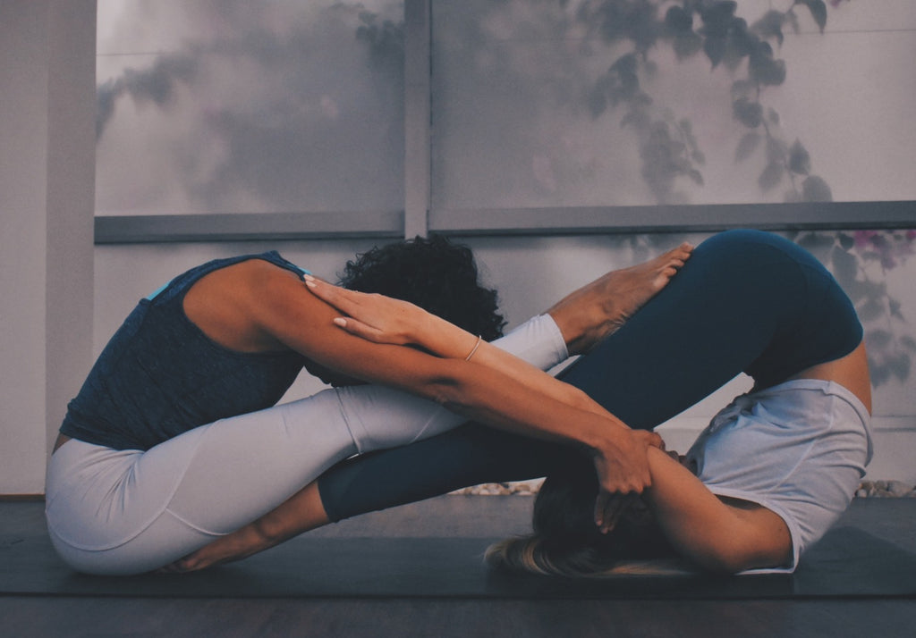 two people practicing acro yoga