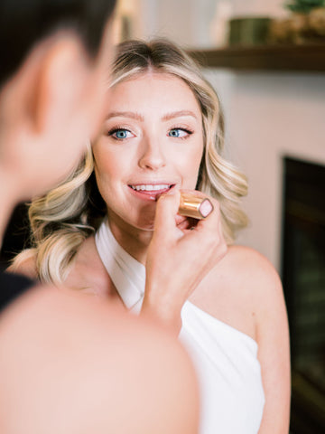 Bride gets her makeup done and artist applies her lipstick.