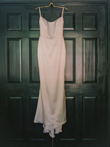 Wedding dress hanging on the door.