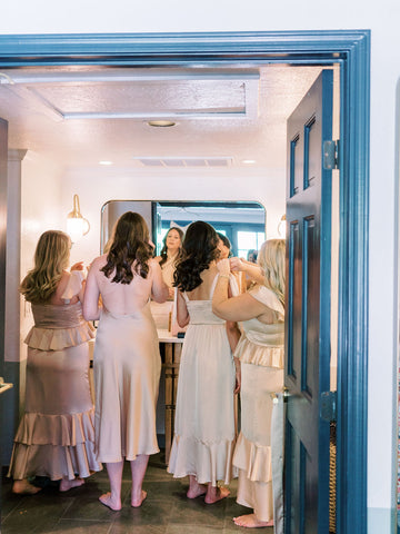 Bridal party gets ready together in the bathroom.