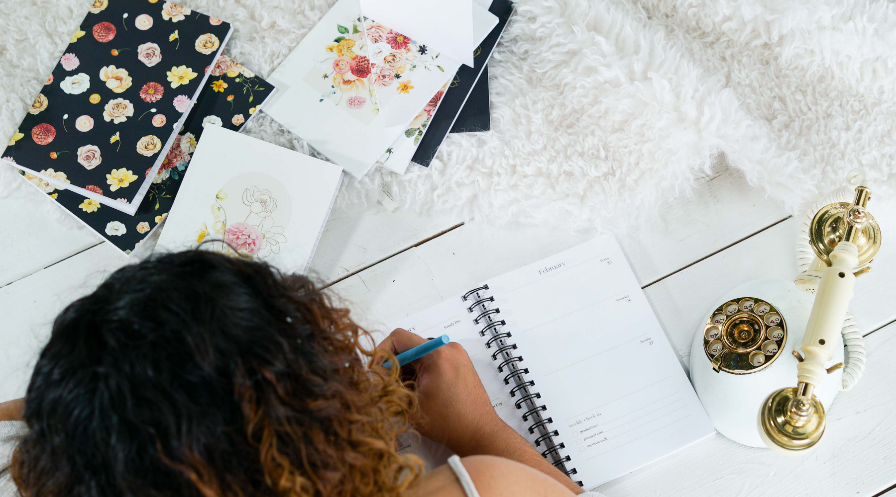 Girl writing in 16 month Agenda surrounded by books