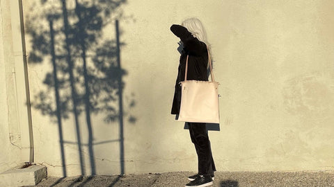 Edie Kahula Pereira modeling Edie Kahula Pereira Goods (aka Specialty Dry Goods) Raffia bag in veg tan leather self shooting  IRL in her Santa Monica neighborhood.