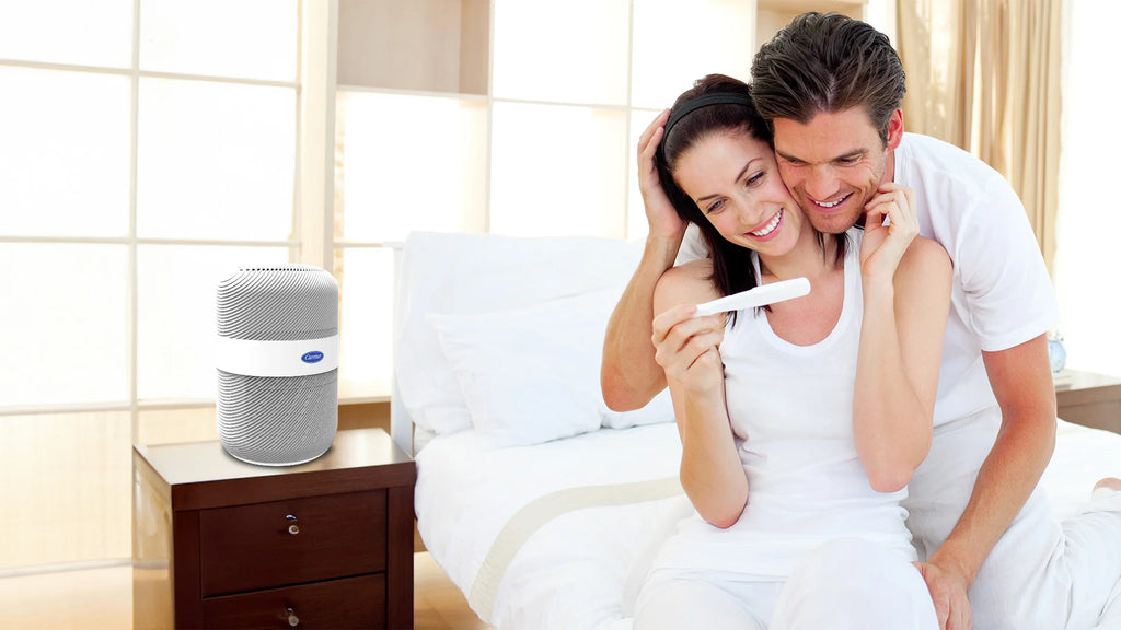 husband-and-wife-checking-a-pregnancy-test-with-carrier-tabletop-air-purifier-on-their-bed-side-table