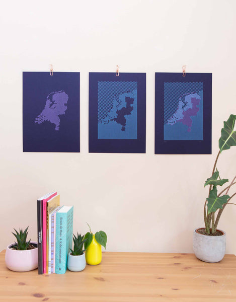 Triptych of Navy letterpress map 'Below the Sea' showing 2 layers of coloured print next to final print on wall.