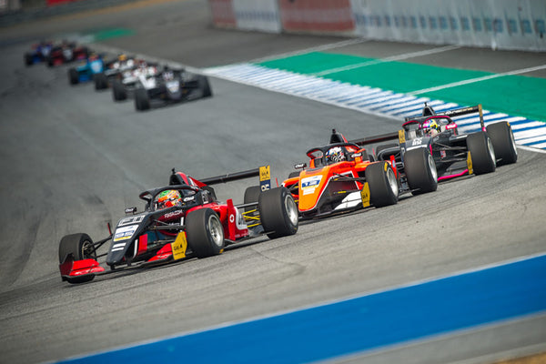Three F3 cars compete for position during a turn