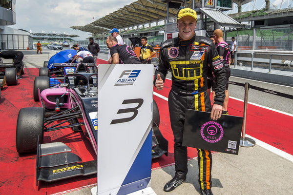 Oloi driver Brendon Leitch gives a thumbs up next to the pink Oloi F3 car