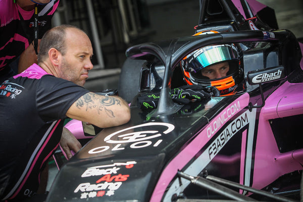 Driver Brendon Leitch speaks to BlackArts Racing team member from inside the cockpit of the pink Oloi F3 car