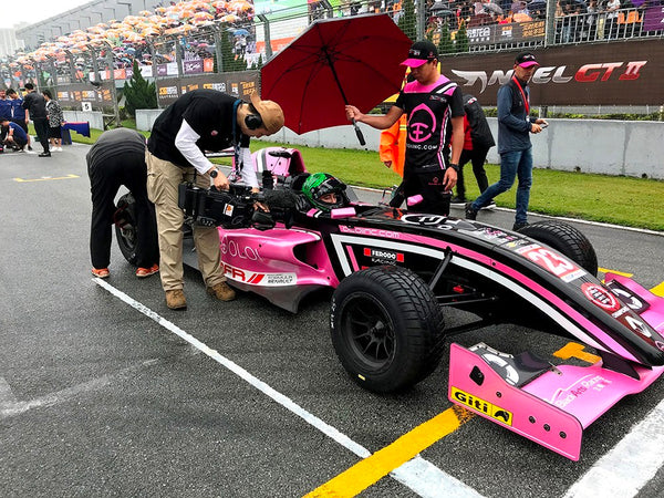 Asian Formula Renault media team member gets a closeup shot of Joey Alders in the cockpit of the pink Oloi car on the starting grid