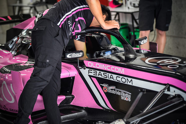 A BlackArts Racing technician tends to the pink Oloi F3 car