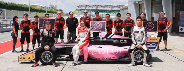 Drivers and crew of BlackArts Racing powered by Oloi pose with pink Oloi F3 car