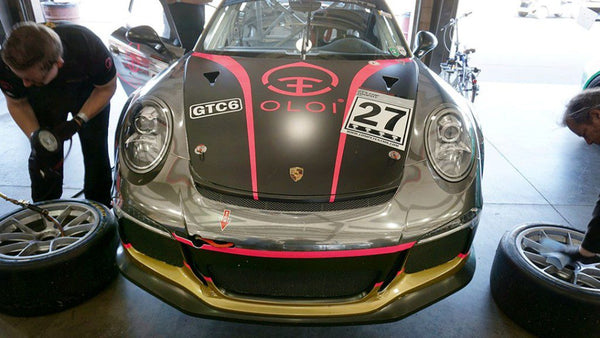 Oloi's Porsche 911 Cup car receiving a tire change in the garage at Buttonwillow Raceway