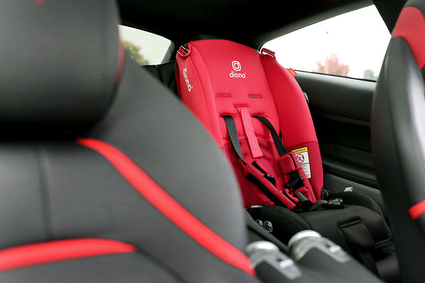 Child's car seat in the rear seat to match the black and red upholstery