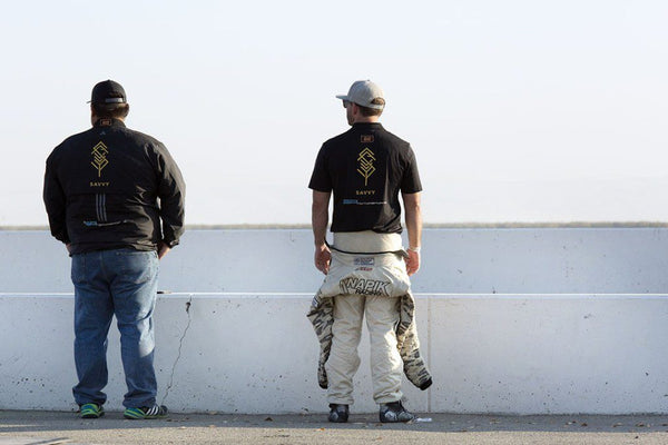 Techician and driver look on over the track at Buttonwillow Raceway