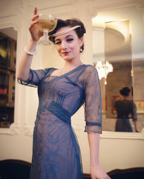 Lady wearing a cocktail blue dress inspired by vintage era fashion