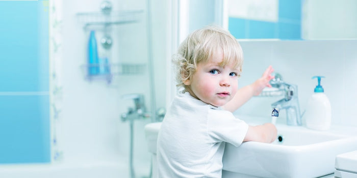 Kind öffnet Wasserhahn mit Schwung und spritzt sich nicht voll dank Konstanthaltung