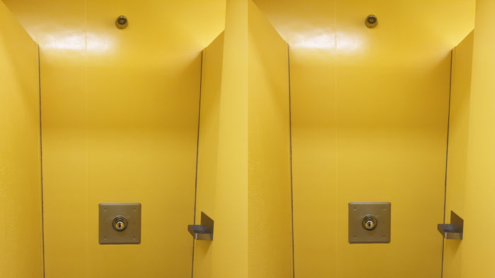 zwei Duschkabinen in gelben Leichtbau-Wänden