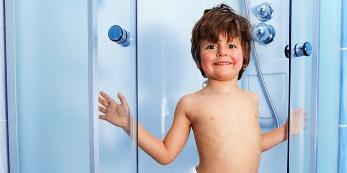 kleiner Junge in einer Duschkabine
