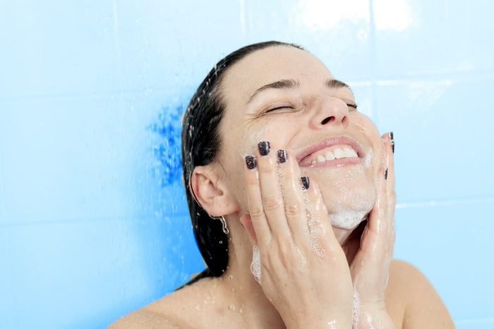 Jeune femme qui rit dans la douche