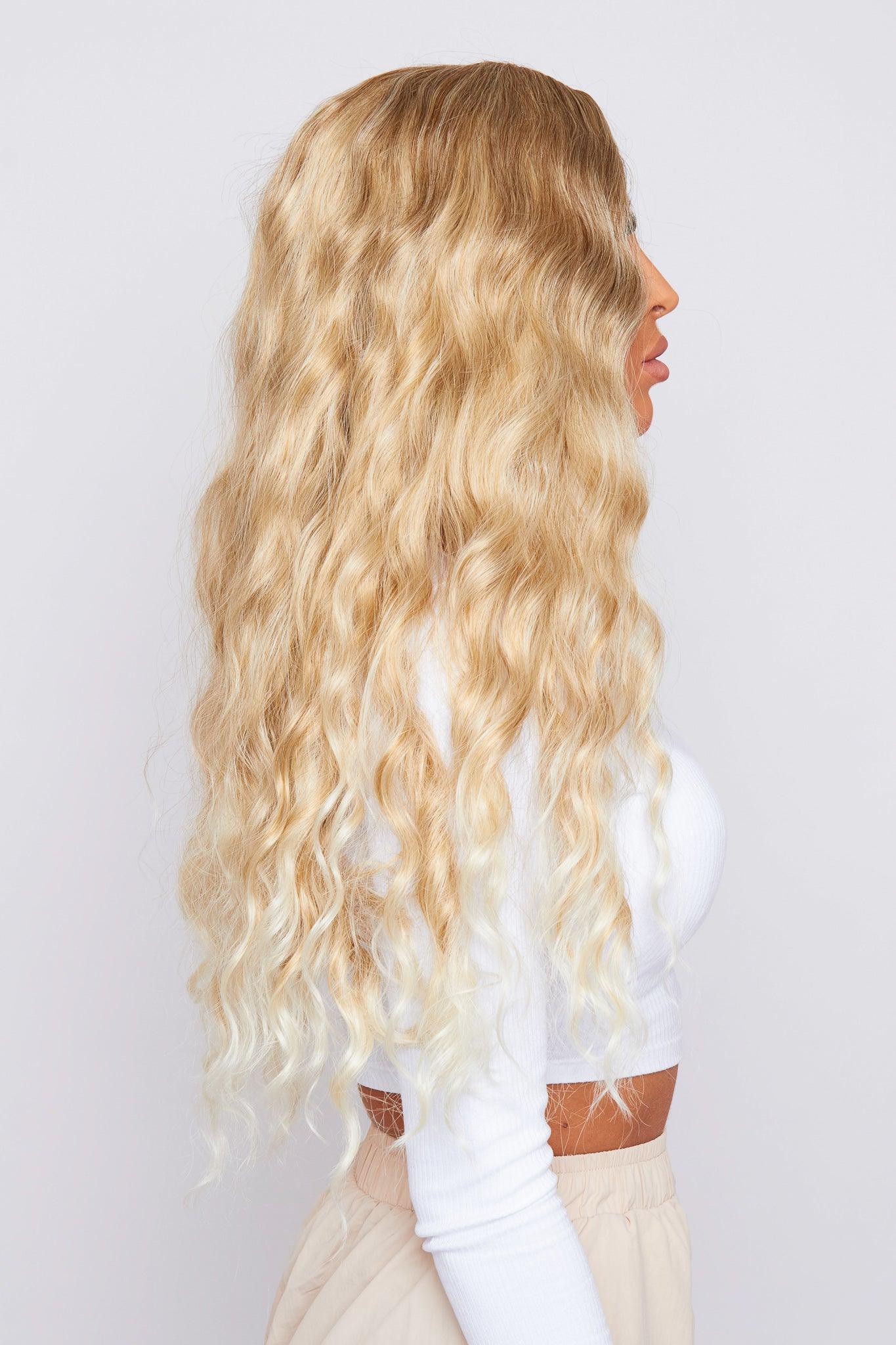 synthetic blonde curly hair wig from pbeauty hair being worn by model wearing a white top