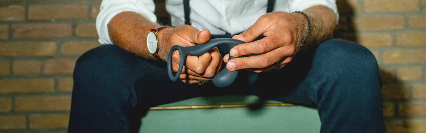 A person holding a bootie ring butt plug by fun factory