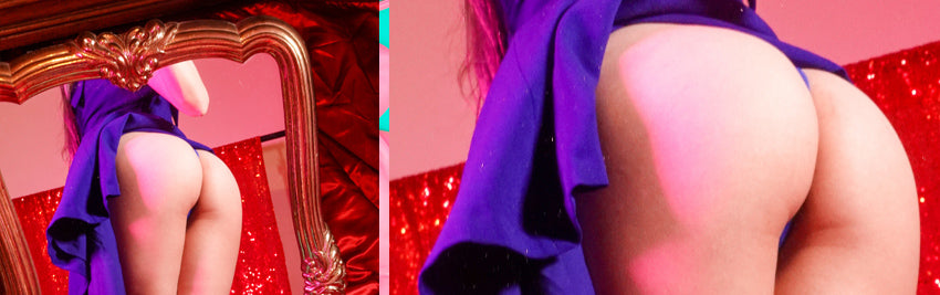 Cy in purple dress showing butt in mirror, pink monstera leaf hiding butt