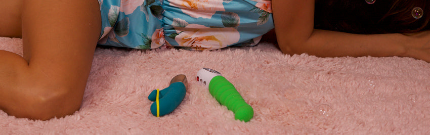 A person laying down next to a Patchy Paul and an Amorino rabbit vibrator