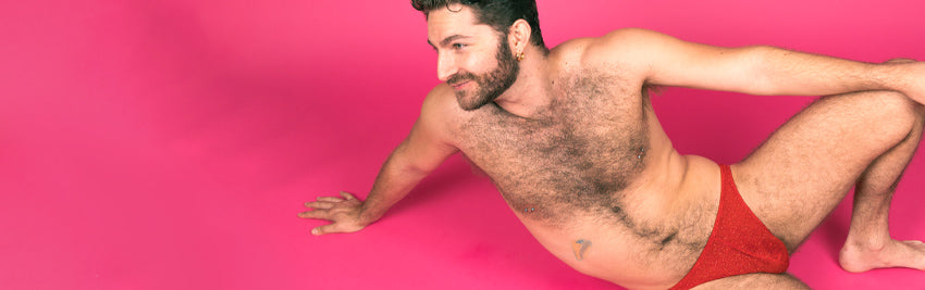 Zachary Zane posing on a pink floor in his red underwear