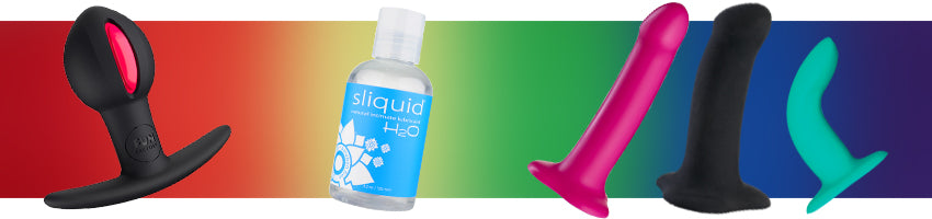 Queer Toys Options: B Balls, Lube, and Dildos against rainbow background