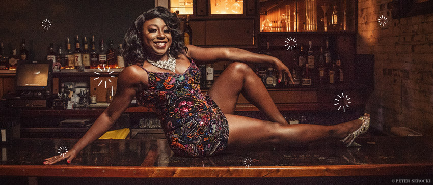 Burlesque star Shimmy LaRoux posing on a bar