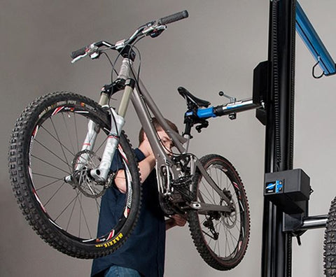 bike on repair lift with a bike mechanic performing routine tune-up
