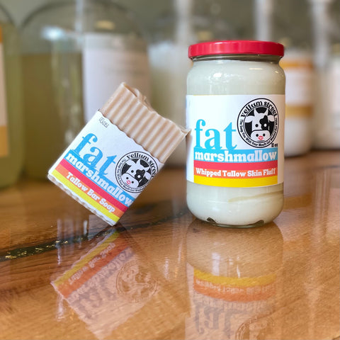 a jar of vellum street's fat marshmallow whipped tallow skin fluff sits on a wooden counter top next to a bar of fat marshmallow tallow bar soap