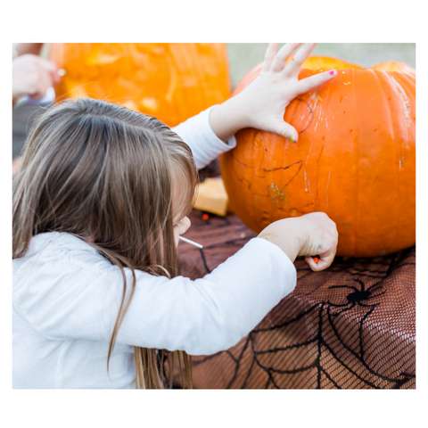 young girl carving pumpkin