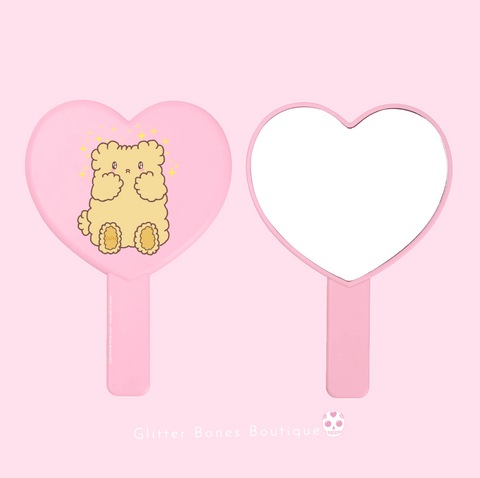 Osito a cute teddy bear on a pink heart shaped mirror