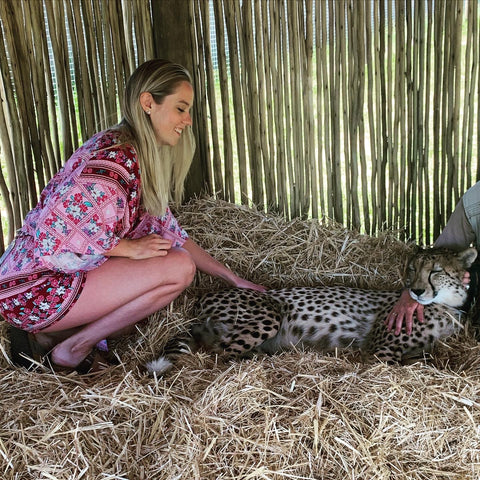 Kelly the macra-maker in South Africa petting a cheetah