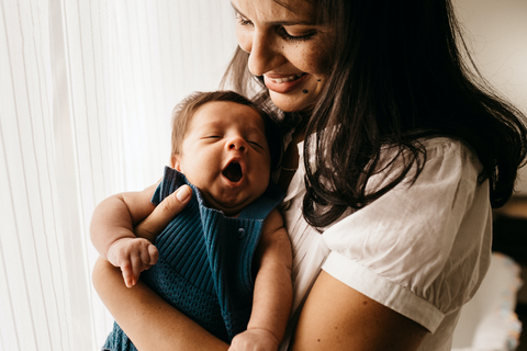 women holding her baby that is yawning