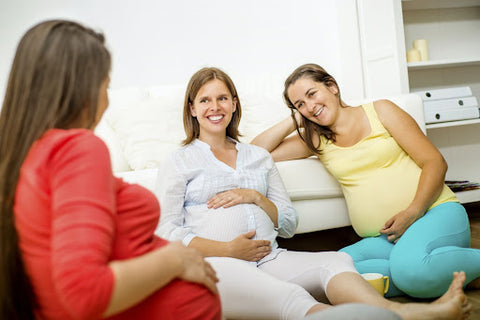 3 Pregnant women talking and smiling with each other