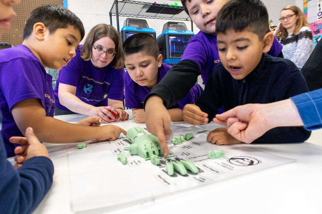 Peck Elementary School Students assemble a 3D Printed e-NABLE hand for a recipient in need of a new hand.